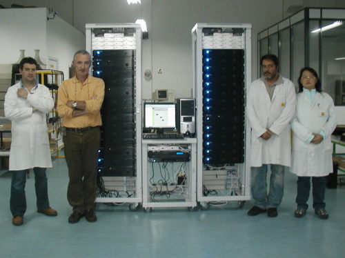 The system, composed of two power and one racks ready for delivery, with the team making the project possible.