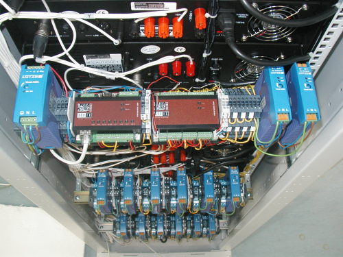Uma vista da traseira de um dos bastidores, mostrando o hardware de comando e supervisão IP, junto com o equipamento responsável
 pela activação dos circuitos de emergência.